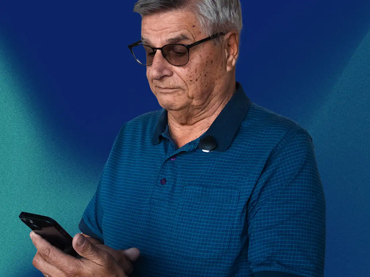 A man with the MYLL device clipped on, looking at the MYLL app on his phone